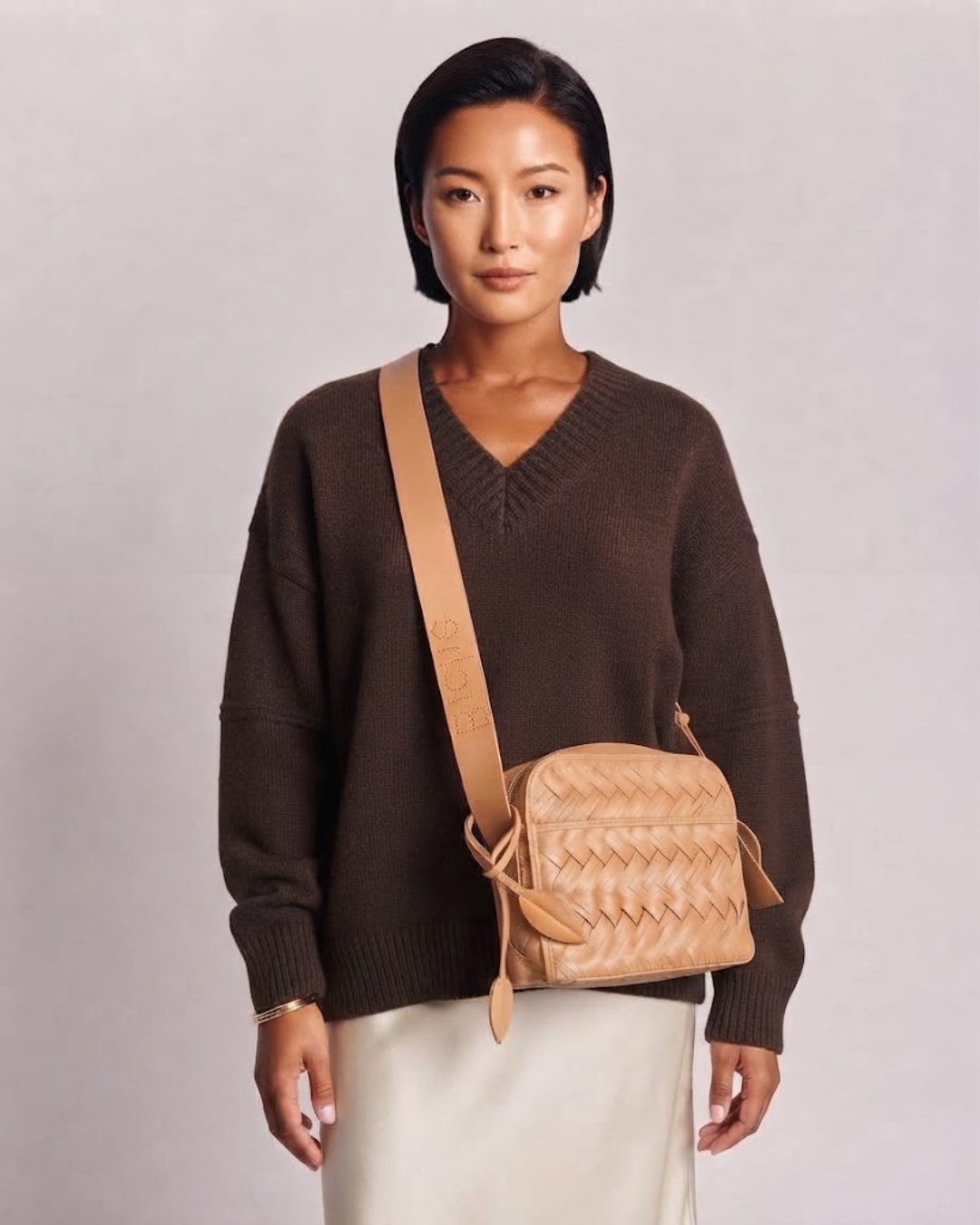 Woman wearing the Aircrew braided calfskin crossbody bag — Biche Maison Dréan