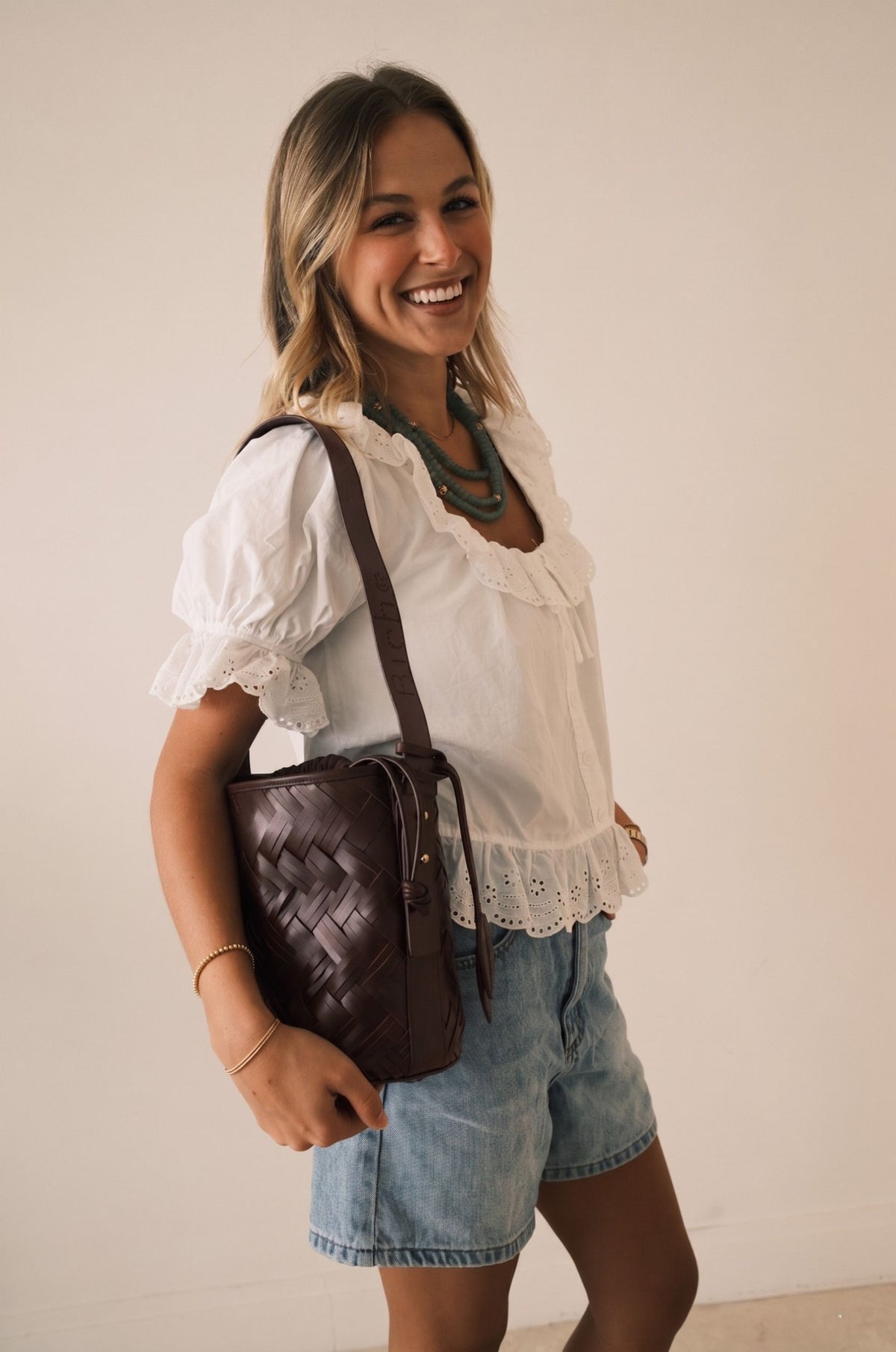 Woman wearing the Bichon V hand-woven leather bucket bag — Biche Maison Dréan