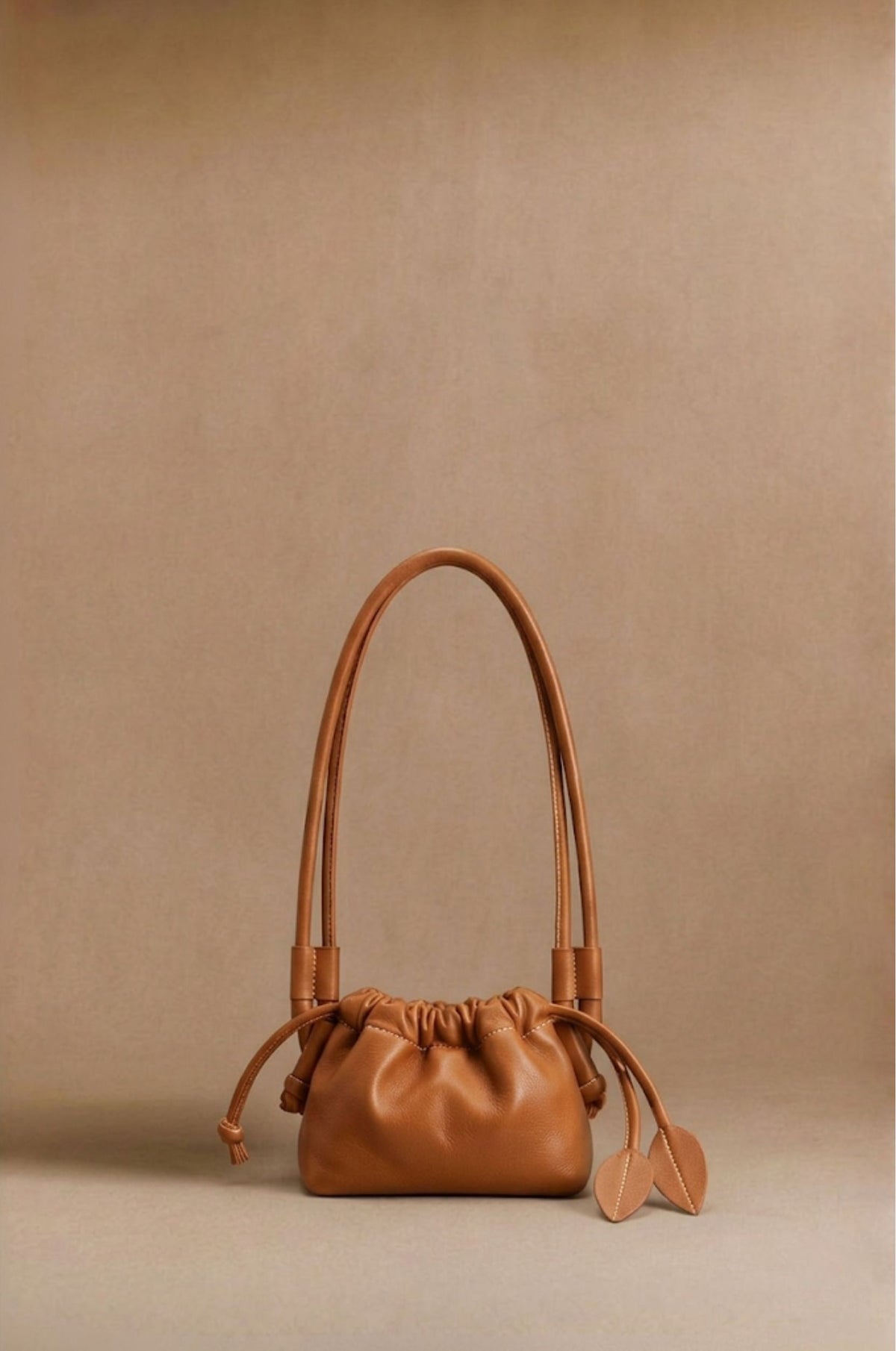Eva Mini drawstring calf leather bag in cognac, front view — Biche Maison Dréan
