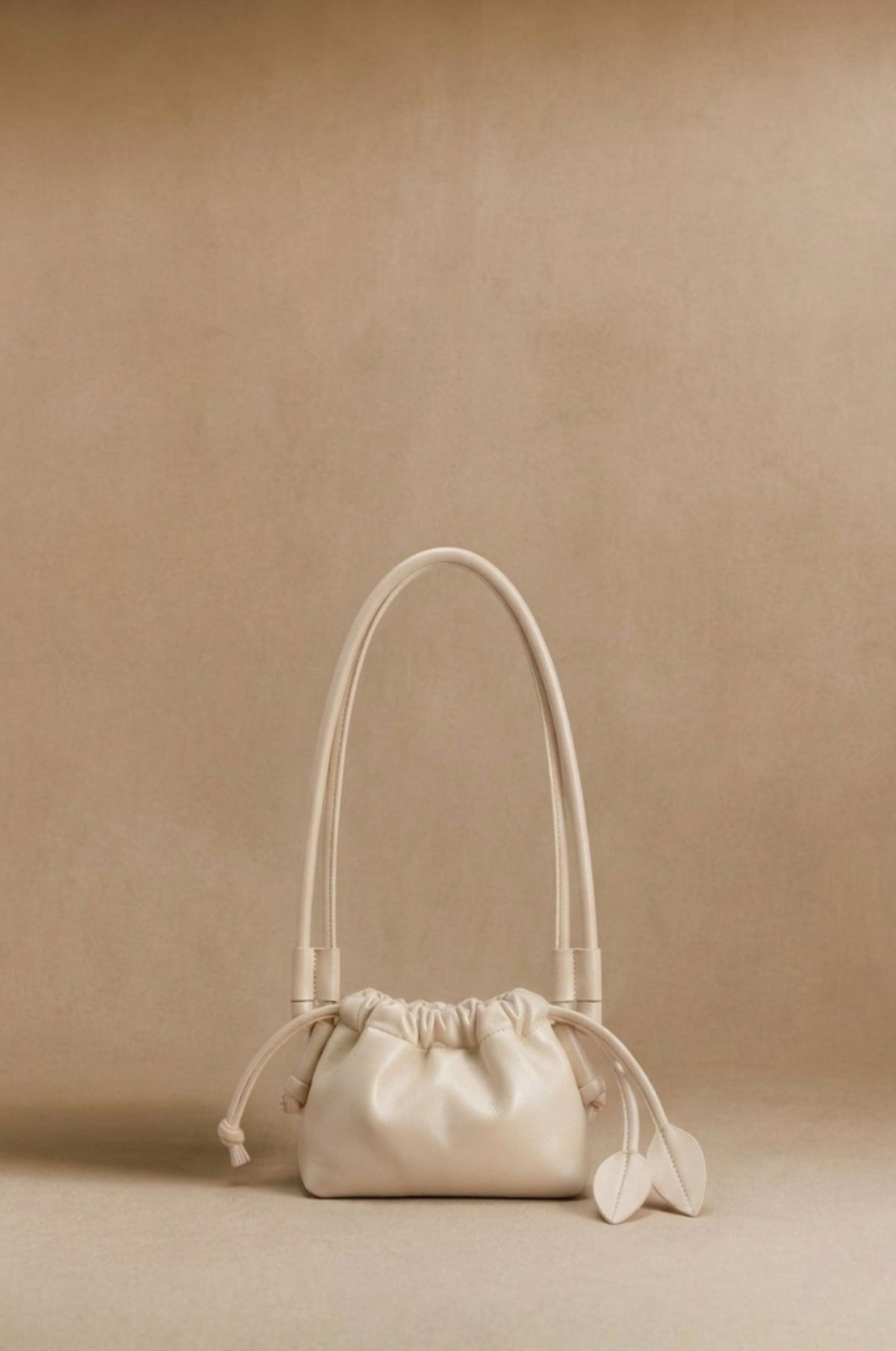 Eva Mini drawstring calf leather bag in beige, front view — Biche Maison Dréan
